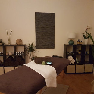 Esempio di una palestra in casa tropicale di medie dimensioni con pareti bianche, parquet chiaro e pavimento beige