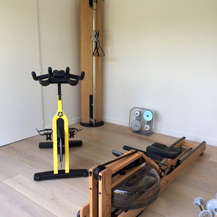 Immagine di una piccola palestra multiuso scandinava con pareti bianche, pavimento in laminato e pavimento beige