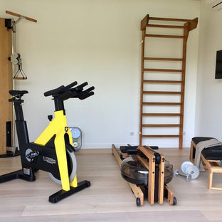 Immagine di una piccola palestra multiuso nordica con pareti bianche, pavimento in laminato e pavimento beige