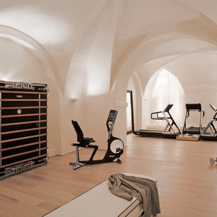 Immagine di una grande palestra multiuso con pareti bianche, pavimento in laminato e pavimento beige
