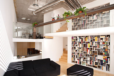 Foto de biblioteca en casa abierta actual con paredes blancas, suelo de madera clara y suelo beige