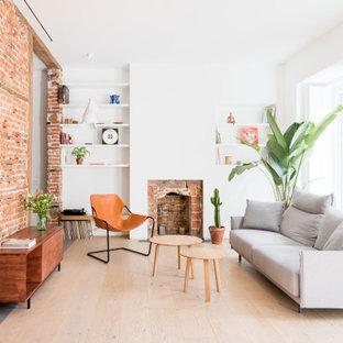 Ispirazione per un soggiorno minimal chiuso con pareti bianche, parquet chiaro, camino classico, cornice del camino in mattoni, pareti in mattoni e pavimento beige