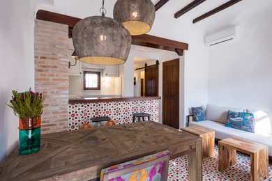Diseño de salón abierto mediterráneo pequeño sin chimenea y televisor con paredes blancas, suelo de baldosas de cerámica y suelo rojo
