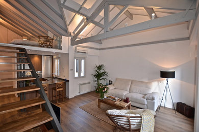 Ejemplo de salón para visitas abierto industrial de tamaño medio con paredes blancas, televisor independiente y suelo de madera en tonos medios