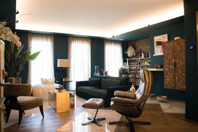Ejemplo de salón con barra de bar ecléctico grande con paredes verdes y suelo de madera en tonos medios