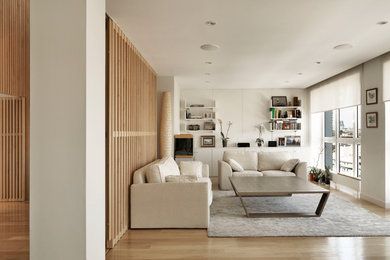 Imagen de salón abierto minimalista pequeño con paredes blancas y suelo de madera clara