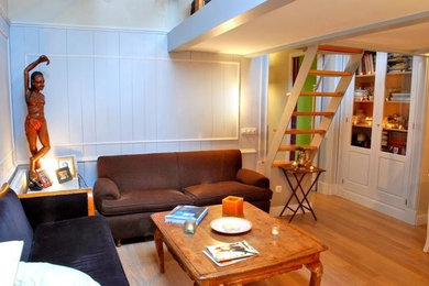 Modelo de salón para visitas cerrado bohemio de tamaño medio sin chimenea y televisor con paredes blancas y suelo de madera en tonos medios