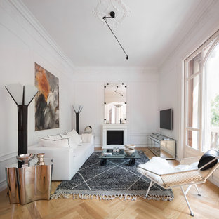 Imagen de salón para visitas escandinavo, grande, con paredes blancas, suelo de madera clara, todas las chimeneas, televisor colgado en la pared y suelo beige