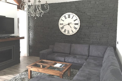 他の地域にある中くらいなカントリー風のおしゃれなLDK (白い壁、ラミネートの床、薪ストーブ、石材の暖炉まわり、壁掛け型テレビ、ベージュの床) の写真