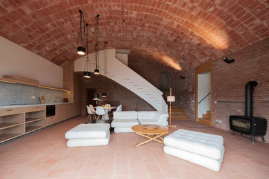 Modelo de salón para visitas abierto mediterráneo grande sin televisor con paredes blancas, suelo de baldosas de terracota y estufa de leña