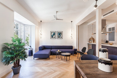 Imagen de salón para visitas abierto actual de tamaño medio sin chimenea y televisor con paredes blancas y suelo de madera en tonos medios