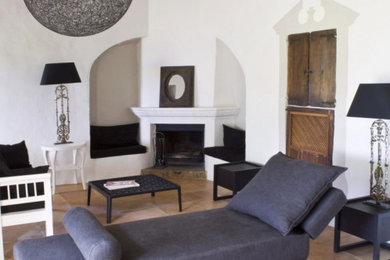 マヨルカ島にある高級な中くらいなエクレクティックスタイルのおしゃれなLDK (白い壁、テラコッタタイルの床、標準型暖炉、漆喰の暖炉まわり、テレビなし、茶色い床) の写真