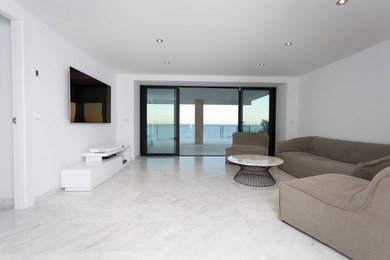 Diseño de salón abierto moderno grande con paredes blancas y televisor colgado en la pared