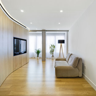 Modelo de salón contemporáneo con paredes blancas, suelo de madera clara, pared multimedia y suelo beige