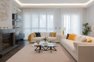 Imagen de salón contemporáneo sin televisor con paredes blancas, chimenea lineal y marco de chimenea de metal