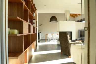 Diseño de salón abierto clásico renovado de tamaño medio con suelo de baldosas de cerámica, chimenea de doble cara y televisor independiente