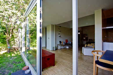Exempel på ett stort skandinaviskt allrum med öppen planlösning, med ett bibliotek, beige väggar, ljust trägolv, en fristående TV och beiget golv