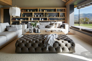Diseño de salón abierto campestre grande con suelo de madera clara, paredes grises y suelo marrón