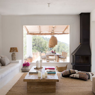 Imagen de salón mediterráneo, sin televisor, con paredes blancas, chimenea de esquina y marco de chimenea de metal