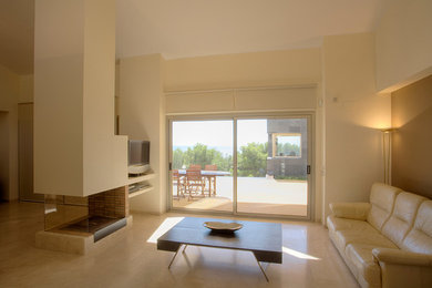 Modelo de salón para visitas abierto tradicional renovado de tamaño medio con paredes amarillas, chimenea de doble cara y televisor independiente