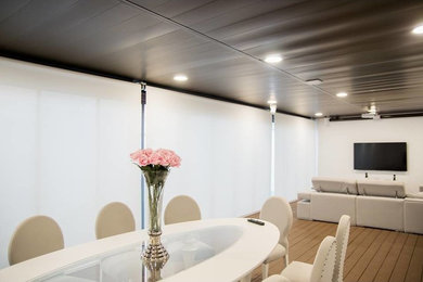 Imagen de salón para visitas cerrado actual grande con paredes blancas, suelo de madera clara, televisor colgado en la pared y suelo marrón