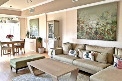 Modelo de salón abierto clásico renovado grande con paredes beige, suelo de madera clara, televisor independiente y suelo beige