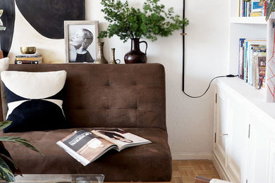 Esempio di un soggiorno boho chic con pareti bianche, pavimento in legno massello medio, TV autoportante e pavimento marrone