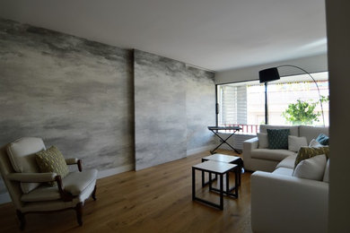 Diseño de salón actual con suelo de madera en tonos medios y televisor colgado en la pared