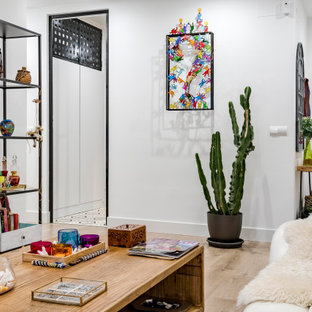 Diseño de salón abierto, ecléctico, con paredes blancas, suelo de madera clara y suelo beige