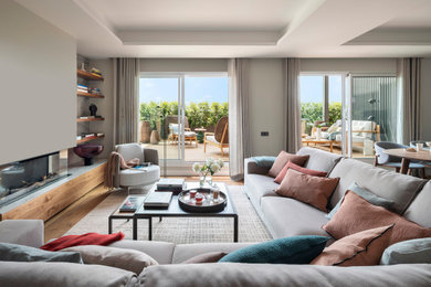 Repräsentatives, Fernseherloses, Offenes Modernes Wohnzimmer mit weißer Wandfarbe, braunem Holzboden, Gaskamin und braunem Boden in Barcelona