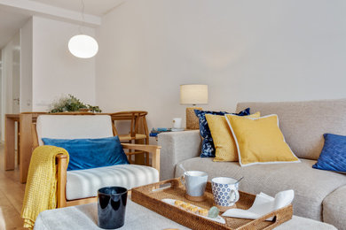Foto de salón abierto contemporáneo de tamaño medio con paredes blancas, suelo de madera en tonos medios, televisor colgado en la pared y suelo marrón