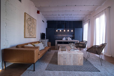 Diseño de salón para visitas abierto contemporáneo grande sin chimenea con paredes blancas, suelo de madera en tonos medios y pared multimedia