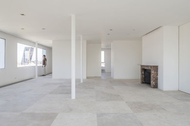 Ejemplo de salón abierto contemporáneo grande con paredes blancas, suelo de piedra caliza, todas las chimeneas, marco de chimenea de piedra y suelo beige