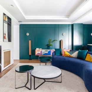 Foto de salón con barra de bar contemporáneo con paredes verdes, suelo de madera en tonos medios, chimenea lineal y marco de chimenea de piedra