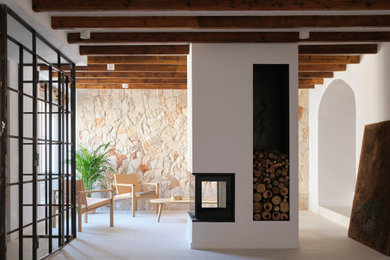 Идея дизайна: гостиная комната в средиземноморском стиле с бежевыми стенами, скрытым телевизором и бежевым полом
