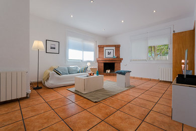 Ejemplo de salón para visitas cerrado tradicional renovado grande con paredes blancas, suelo de baldosas de terracota, chimenea de esquina y pared multimedia