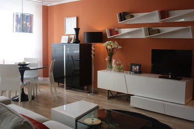 Diseño de salón abierto actual de tamaño medio con parades naranjas y suelo de madera clara