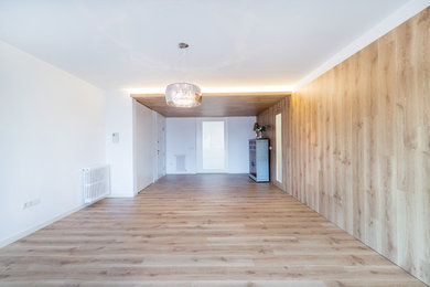 Diseño de salón contemporáneo con paredes blancas y suelo de madera clara