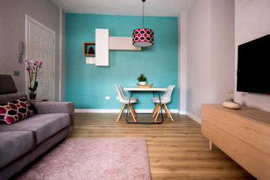 Modelo de salón ecléctico con suelo de madera en tonos medios, estufa de leña, marco de chimenea de metal, televisor colgado en la pared y suelo beige