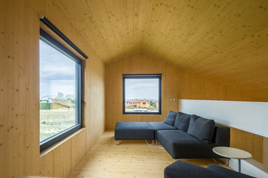 Imagen de salón abierto contemporáneo pequeño con suelo de madera clara