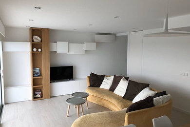 Diseño de salón abierto nórdico de tamaño medio sin chimenea con suelo de madera clara y suelo gris