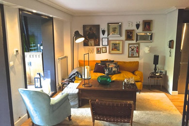 Ejemplo de salón abierto vintage de tamaño medio con paredes blancas, suelo de madera clara y televisor colgado en la pared