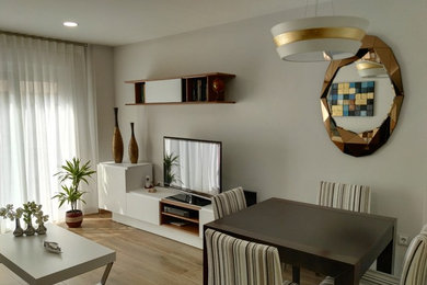 Modelo de salón cerrado moderno de tamaño medio con paredes grises, suelo de baldosas de porcelana y televisor independiente