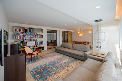 Diseño de biblioteca en casa cerrada contemporánea de tamaño medio con paredes blancas y televisor colgado en la pared