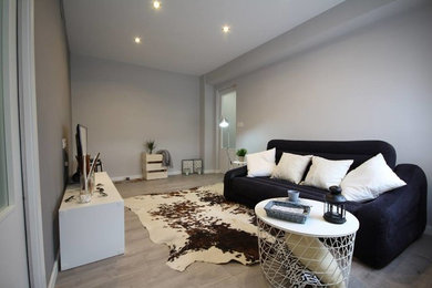 Modelo de salón para visitas cerrado minimalista de tamaño medio con paredes grises y pared multimedia