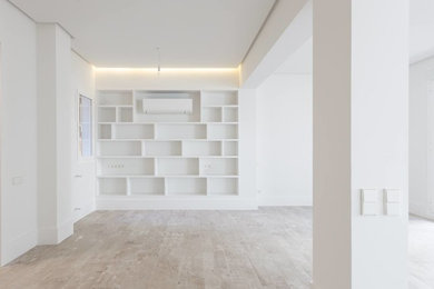 Modelo de salón abierto clásico renovado grande con paredes blancas, suelo de madera clara y suelo beige