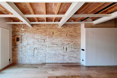 Diseño de salón abierto bohemio grande con suelo de madera en tonos medios, estufa de leña, televisor colgado en la pared, vigas vistas y ladrillo