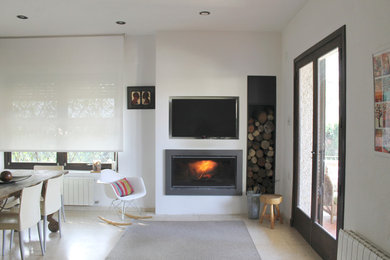 Foto de salón cerrado contemporáneo pequeño con televisor colgado en la pared, paredes blancas, estufa de leña y marco de chimenea de metal