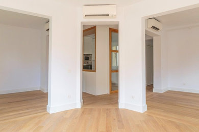 Modelo de salón tradicional renovado con paredes blancas y suelo de madera en tonos medios
