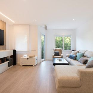 Imagen de salón abierto, contemporáneo, de tamaño medio, sin chimenea, con paredes blancas, suelo laminado, televisor colgado en la pared y suelo beige